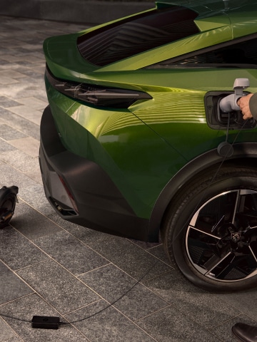 Detail van het zijaanzicht van de Peugeot E-408 tijdens het opladen